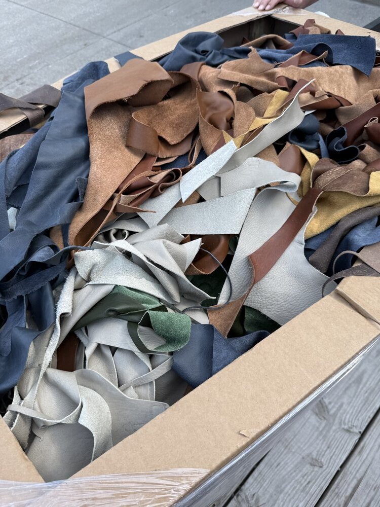 Box of sorted leather scraps showing variety of colors - browns, blues, greens, grays
